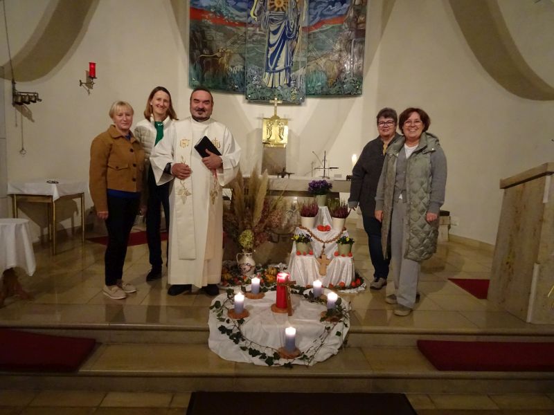 Pfarrvikar Drexler mit den Lektorinnen vor dem geschmückten Altar